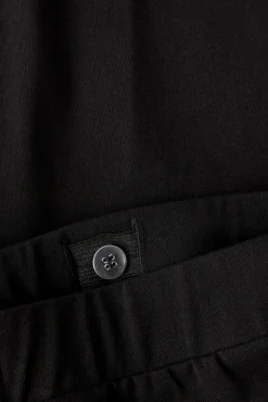 Calça de malha baixa e boca de sino.