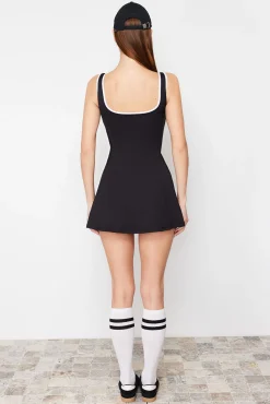 Vestido esportivo preto para tênis com calças e detalhes de vivo